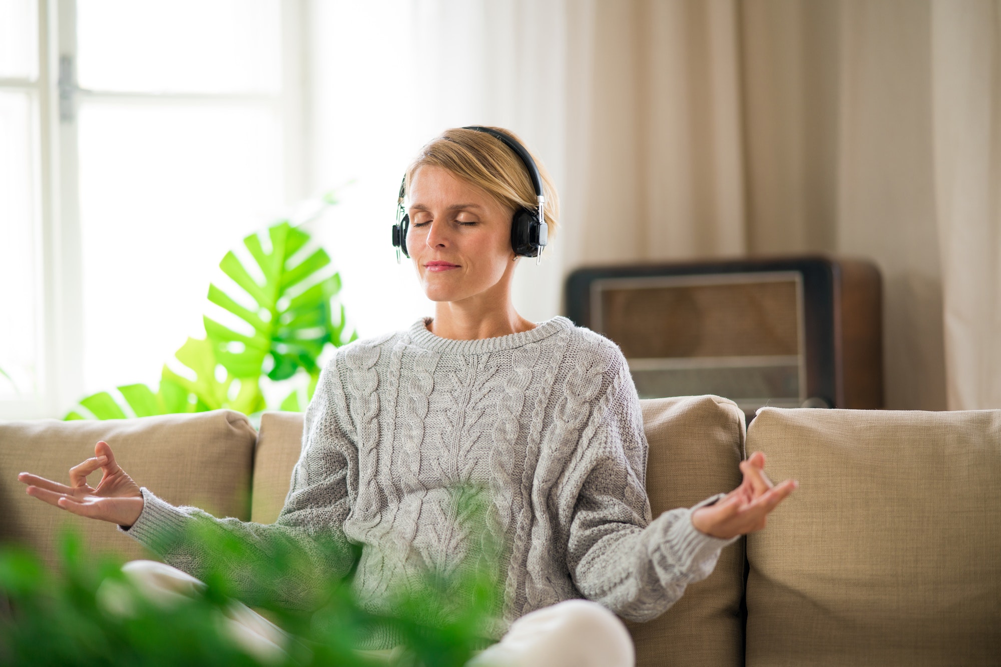 Portrait of woman indoors at home doing yoga, mental health and meditation concept